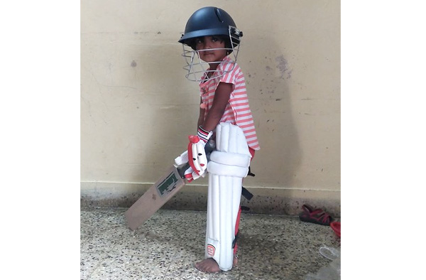 An Indian girl playing cricket in this odd-sized cricket gears